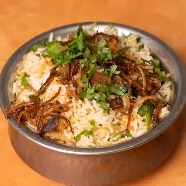 Tandoor Indian Cuisine's chicken biryani, topped with fresh cilantro and crispy fried onions.