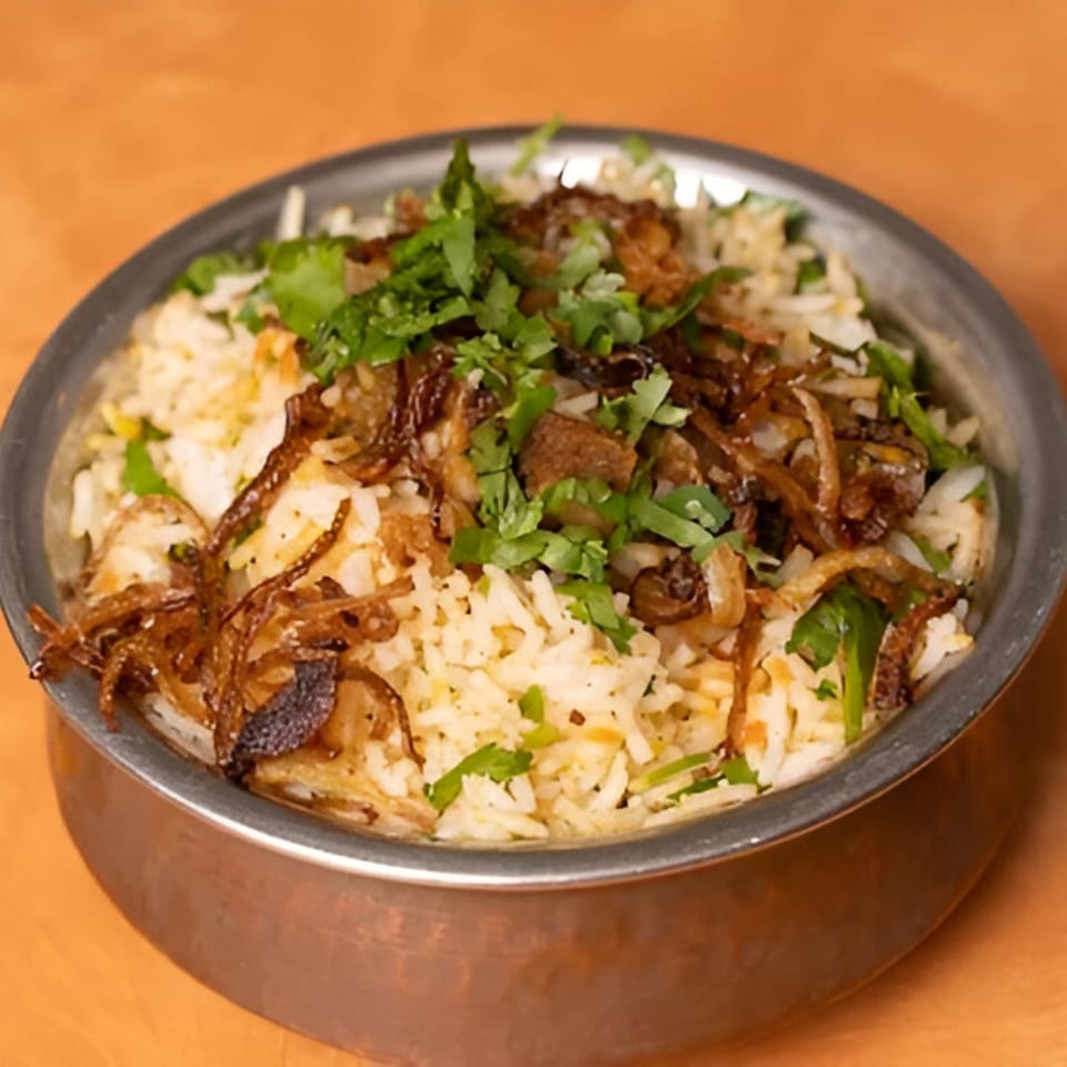 Tandoor Indian Cuisine's chicken biryani, topped with fresh cilantro and crispy fried onions.
